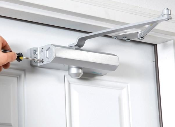 Commercial and residential door closer hardware installed on a modern door in Karachi