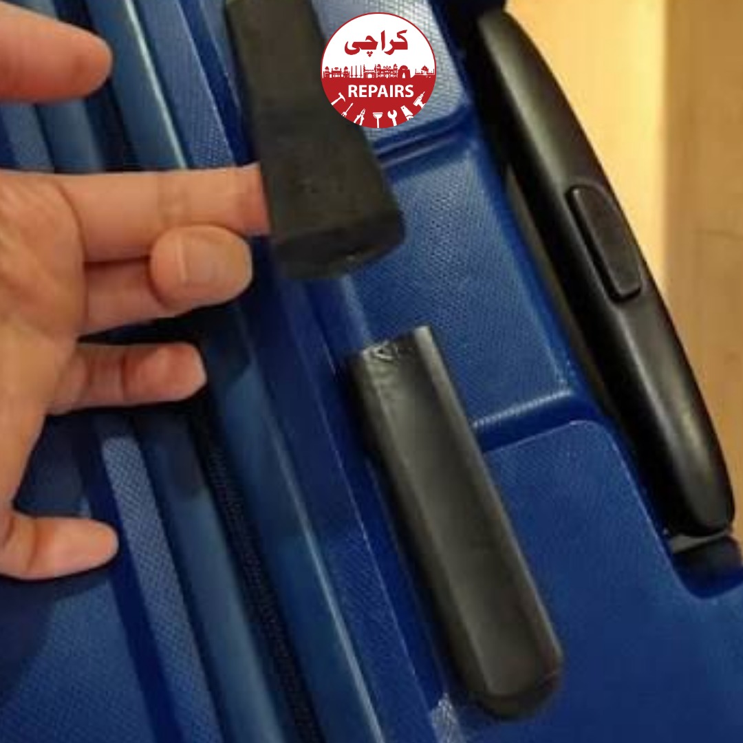 Technician extracting a broken wheel and telescopic handle from an American Tourister suitcase in Karachi