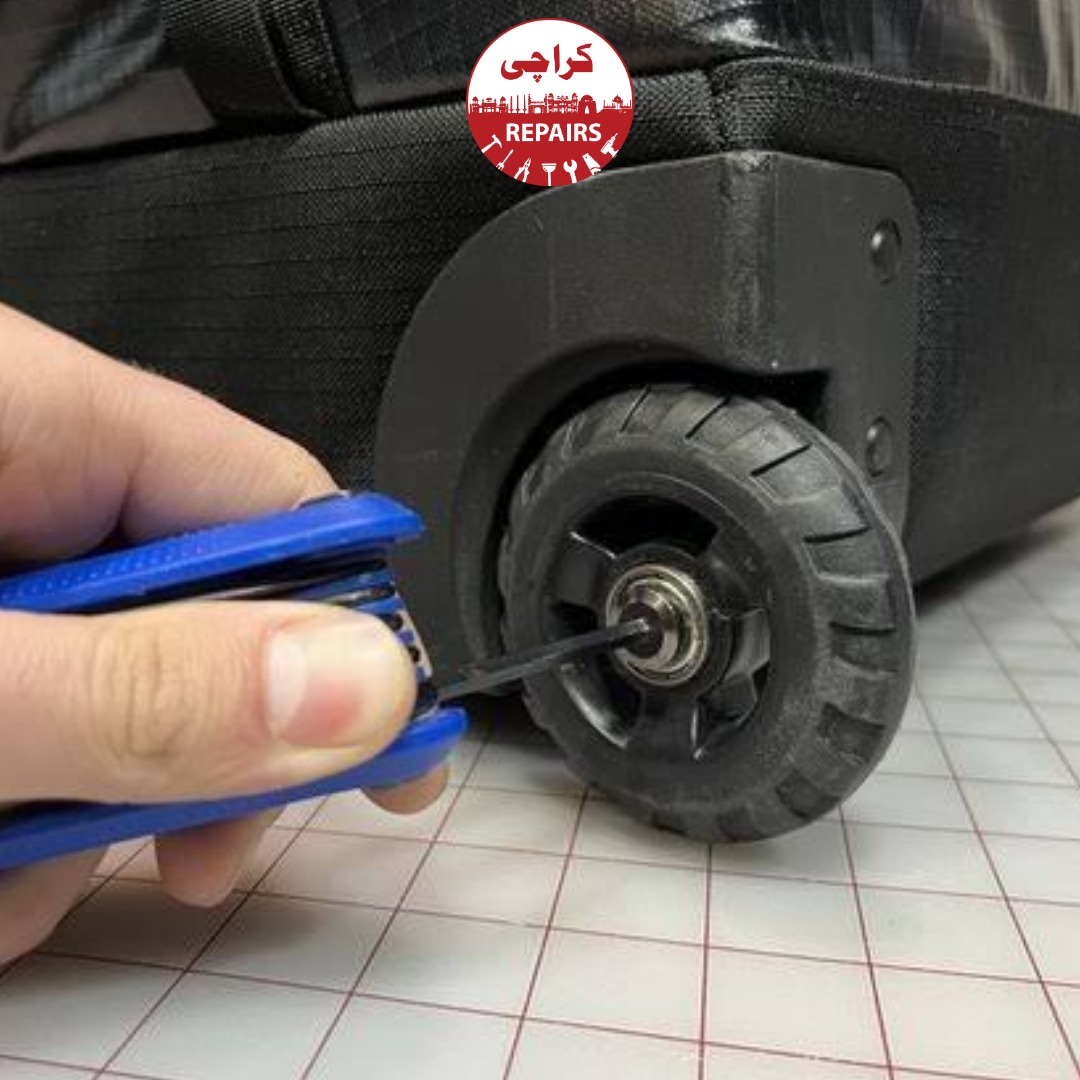 Technician extracting jammed and broken wheels from a travel suitcase in Karachi