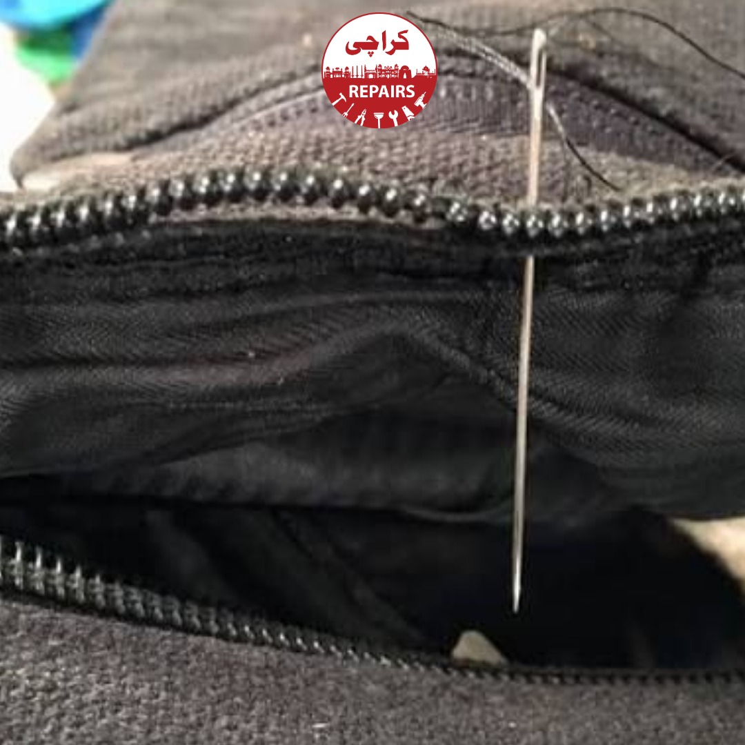 Technician extracting a jammed and split zipper slider from a travel suitcase in Karachi