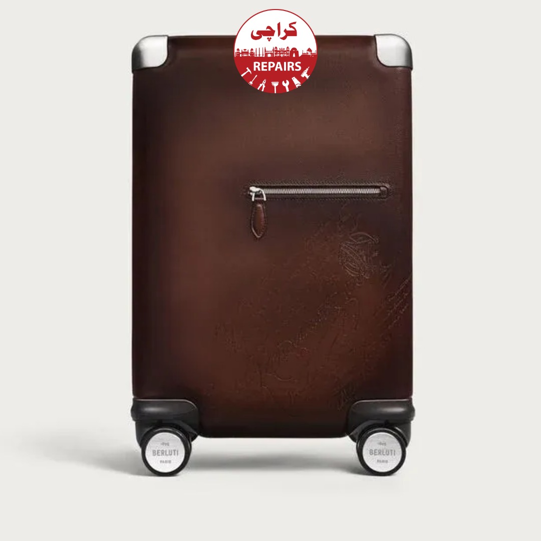 Technician extracting a broken wheel and telescopic handle from a Berluti suitcase in Karachi