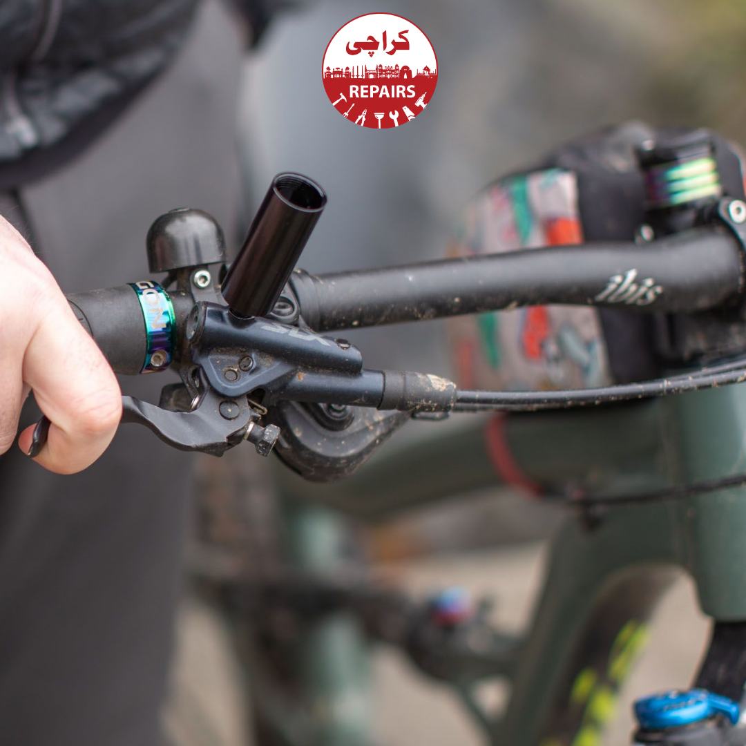 Bike mechanic using a syringe tool to push fresh oil into bicycle brakes in Karachi