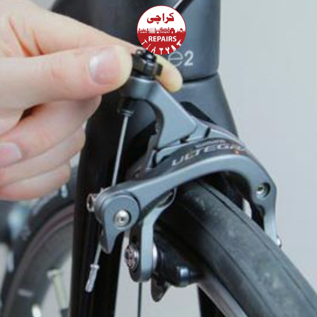 Bike mechanic replacing worn out rubber brake pads on a bicycle wheel in Karachi