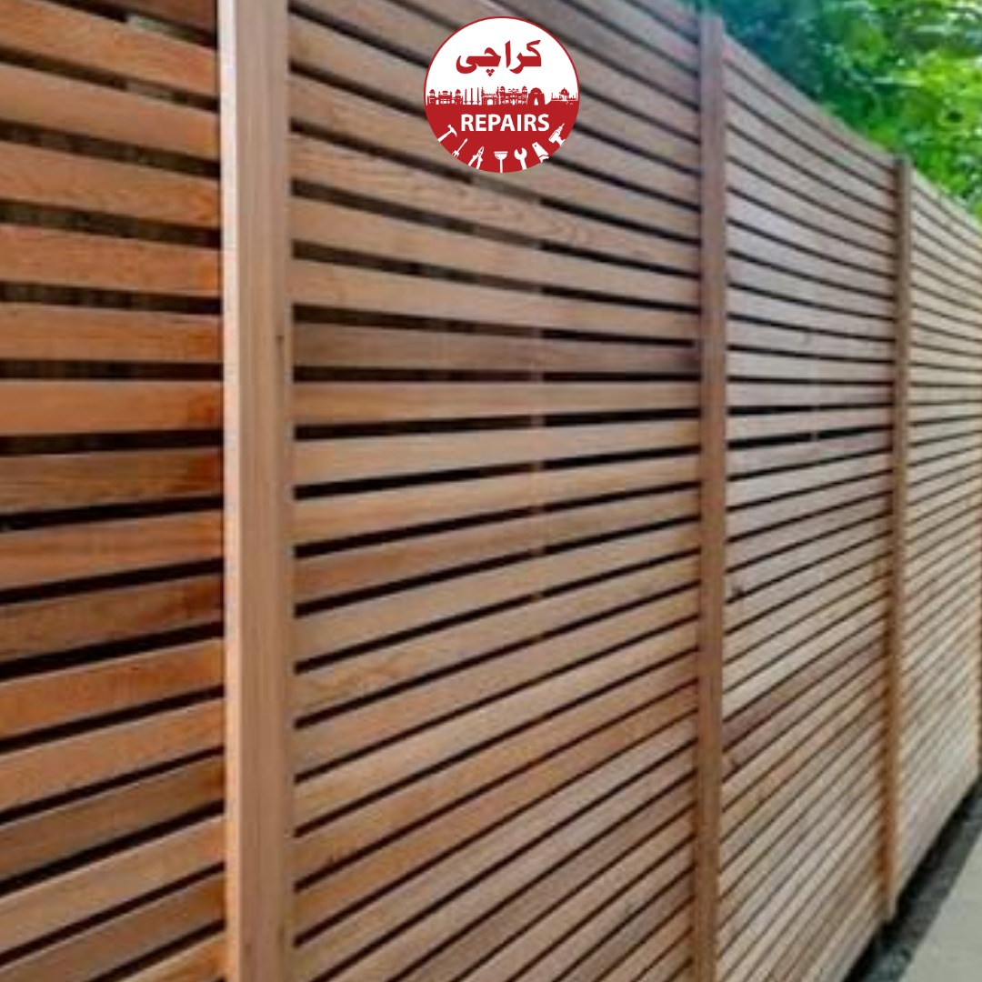 Carpenter installing a new wooden garden fence and privacy screen in Karachi