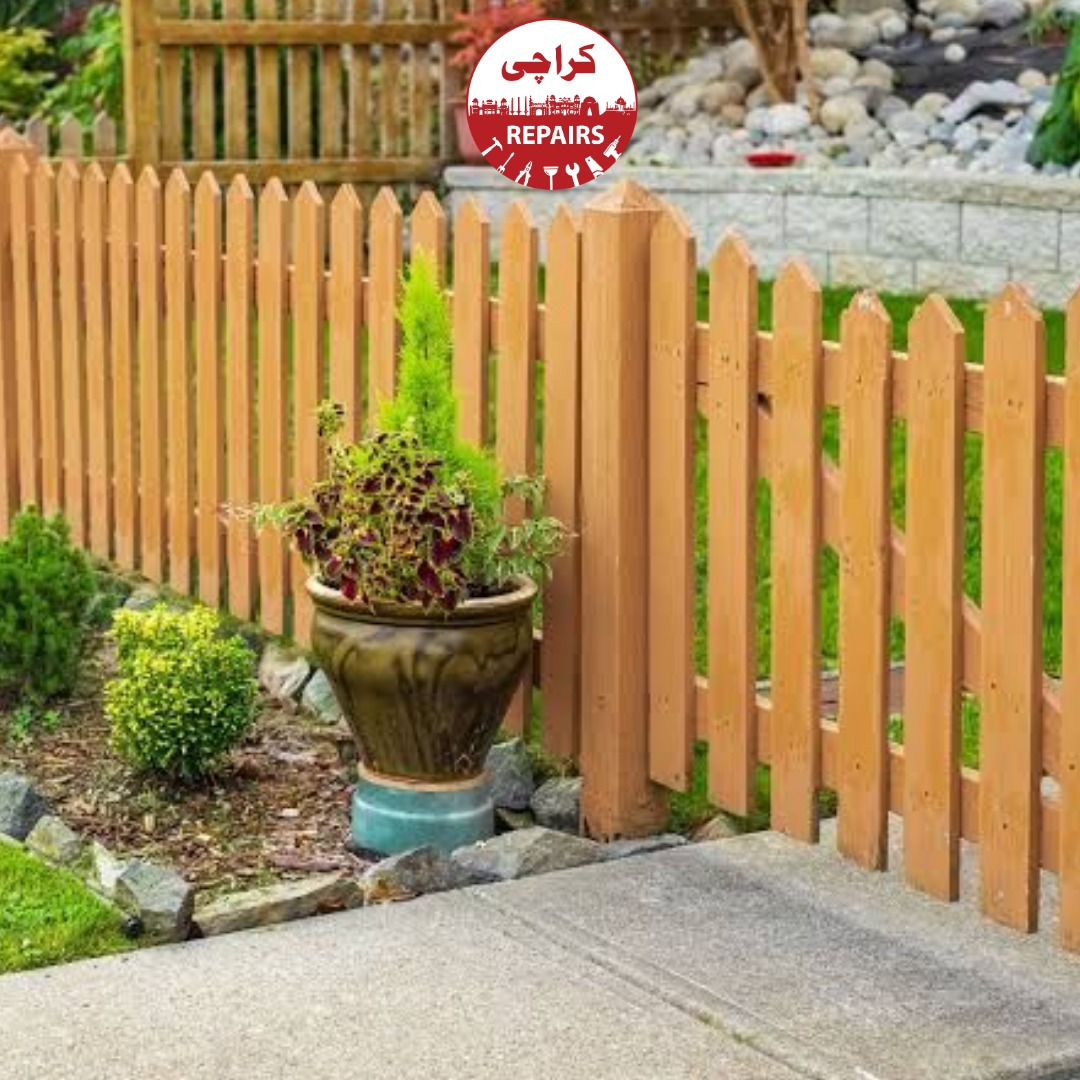 Expert carpenter treating and aligning wooden fence posts in a garden