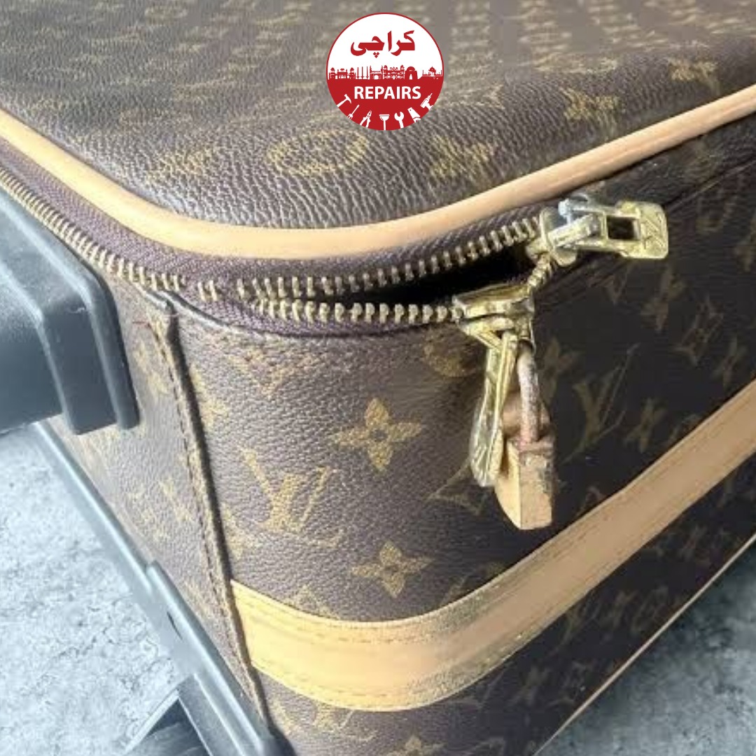 Technician extracting a broken wheel and telescopic handle from a Louis Vuitton suitcase in Karachi