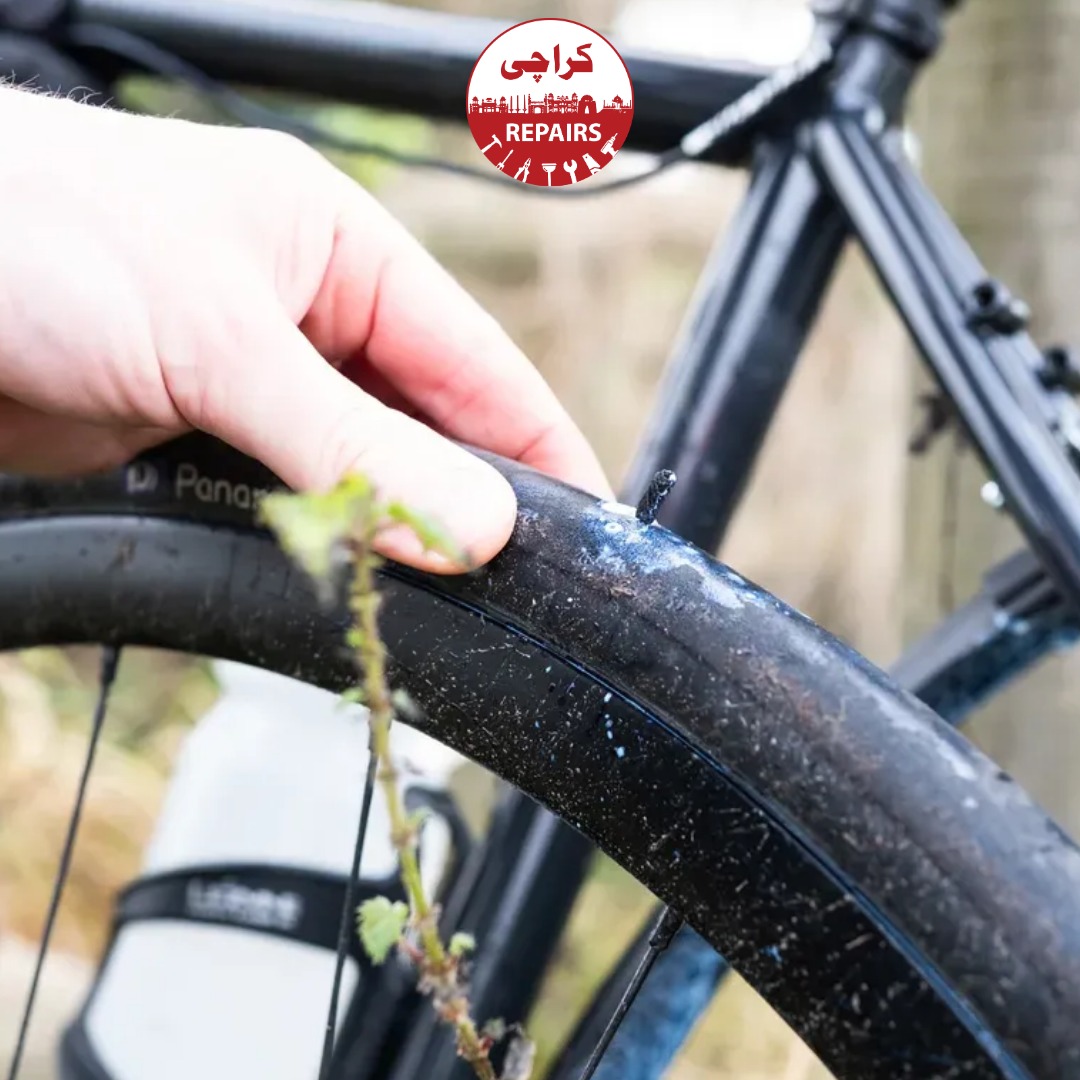 Expert bike mechanic applying strong glue and a rubber patch to a bicycle inner tube
