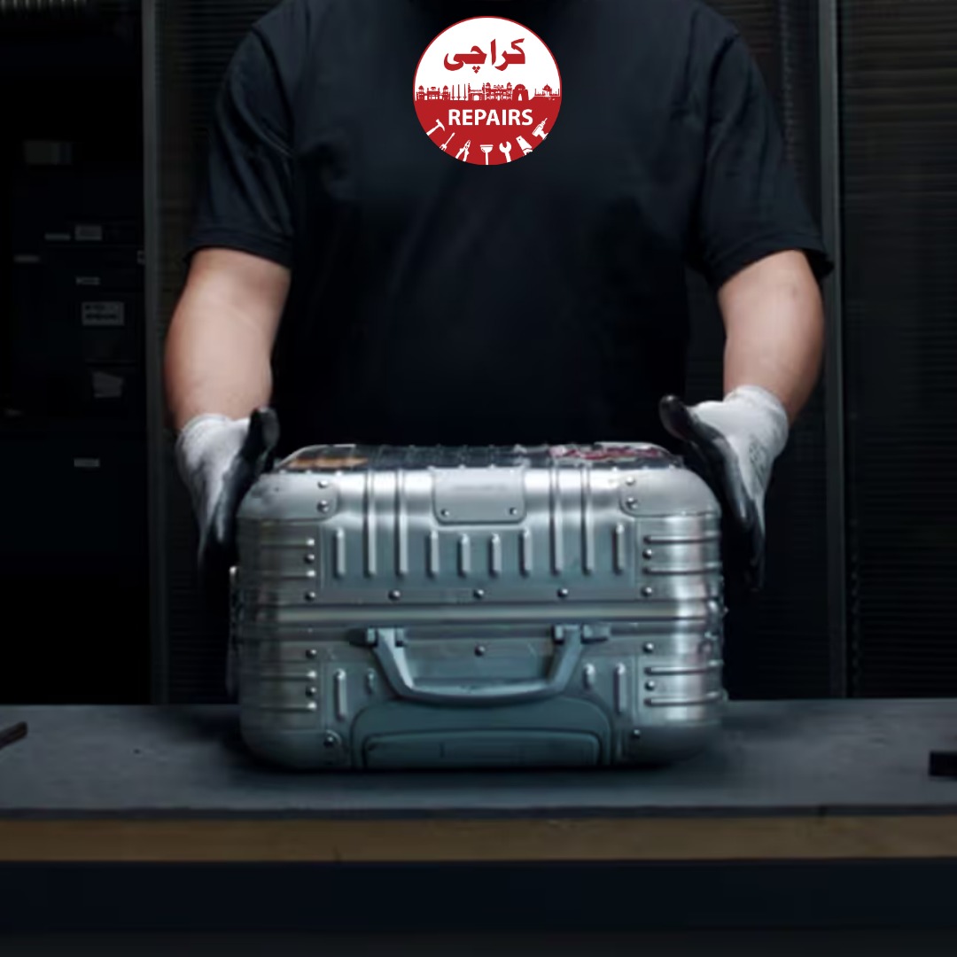 Technician extracting a broken wheel and telescopic handle from a Rimowa suitcase in Karachi