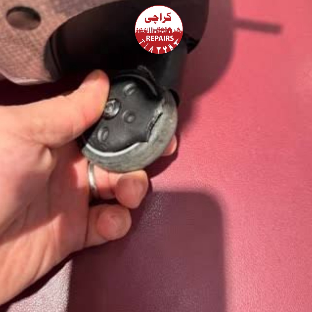 Technician extracting a broken wheel and telescopic handle from a Samsonite suitcase in Karachi