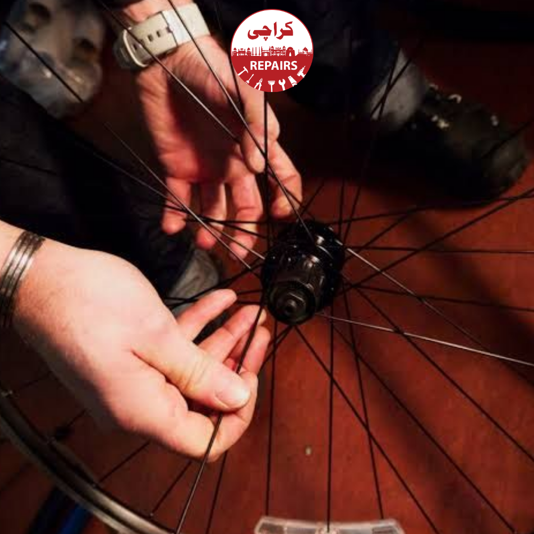 Bike mechanic removing a broken spoke from a bicycle wheel in Karachi