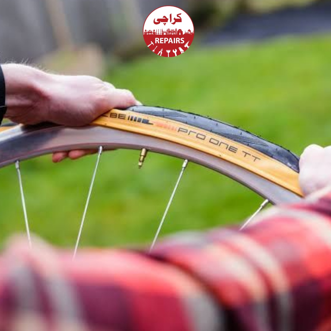 Bike mechanic removing a worn out bicycle tire from the rim in Karachi