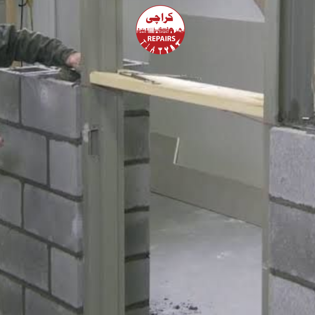 Civil engineers inspecting structural masonry and RCC lintels over a window frame opening in Karachi