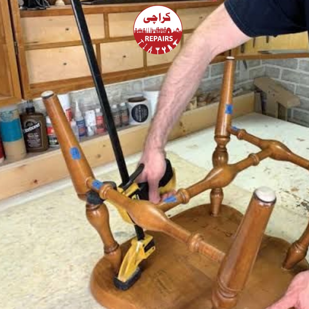 Carpenter gluing and clamping a broken wooden chair in Karachi