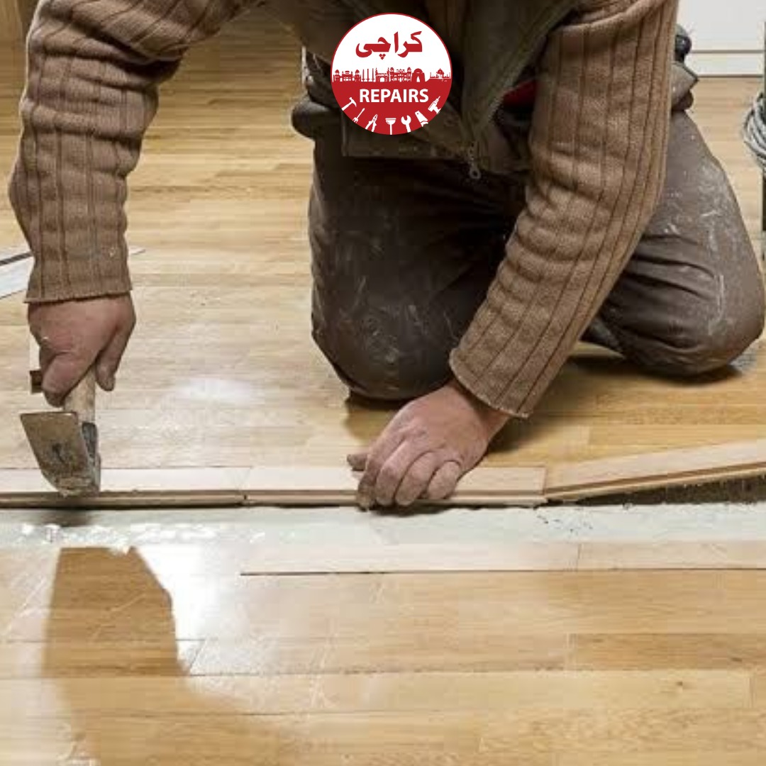 Carpenter replacing water-damaged laminate wooden floorboards in Karachi