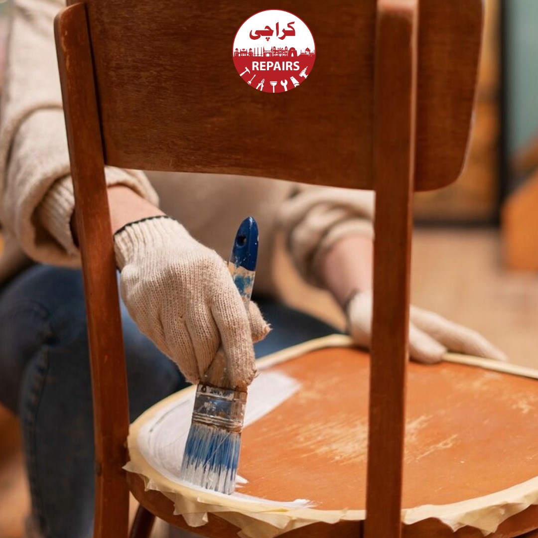 Professional painters applying spray deco paint to furniture while protecting the floors