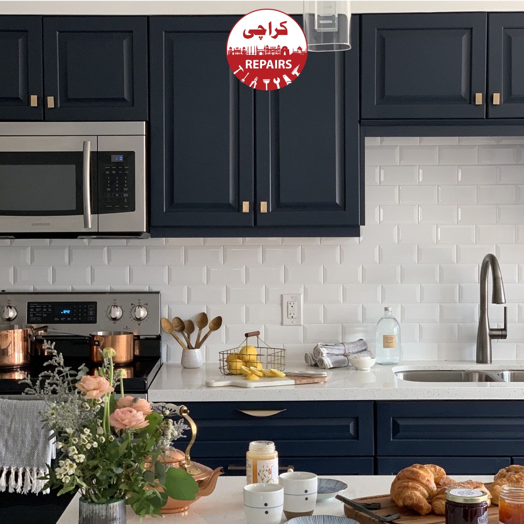 Expert painters sanding, degreasing, and repairing water damaged kitchen cabinets in Karachi